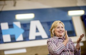 Democratic presidential candidate Hillary Clinton applauds as she sits on stage at a rally at Omaha North High Magnet School in Omaha, Neb., Monday, Aug. 1, 2016. (AP Photo/Andrew Harnik)